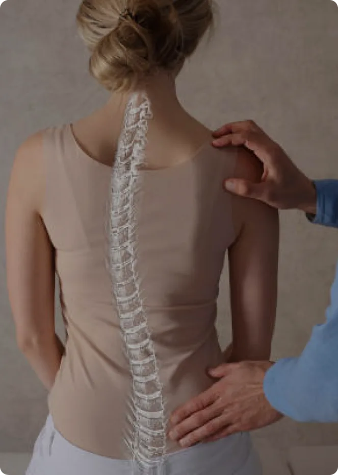 A practitioner's hands assessing a patient's spine